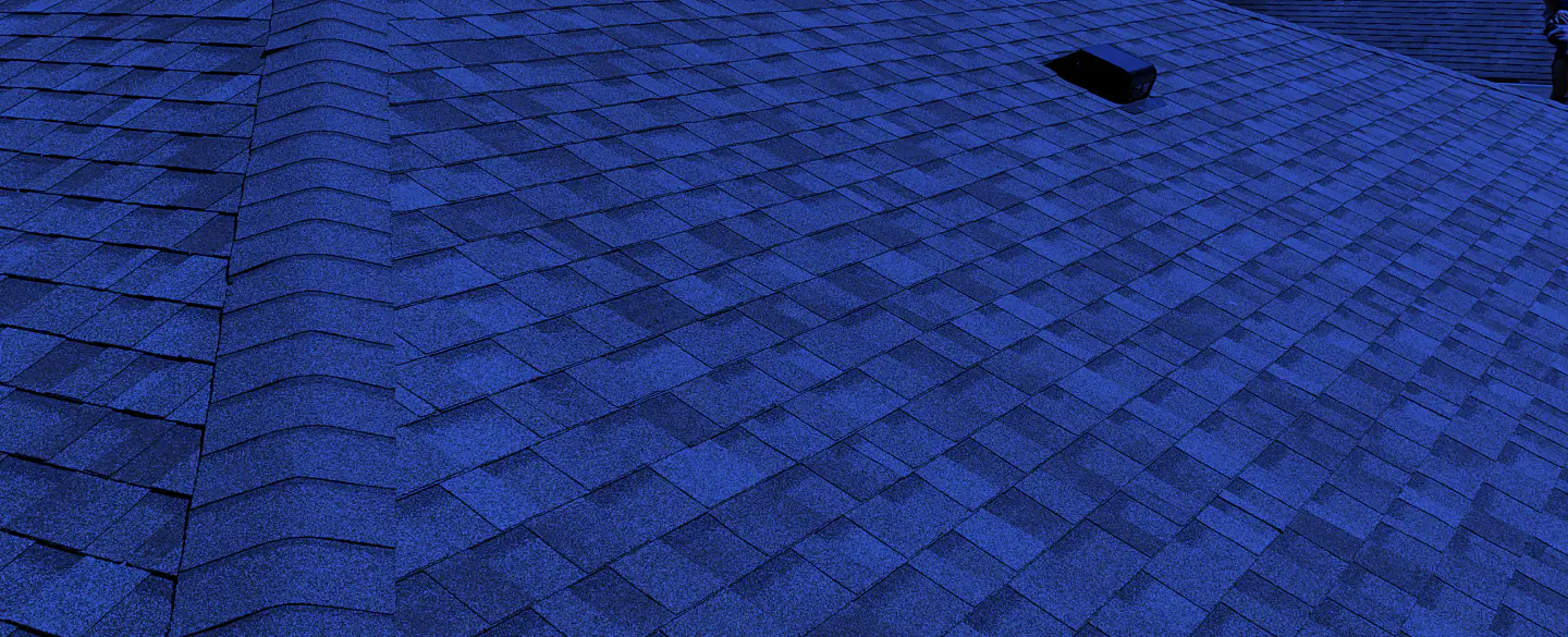 greyish roofing with some black squares on top of it
